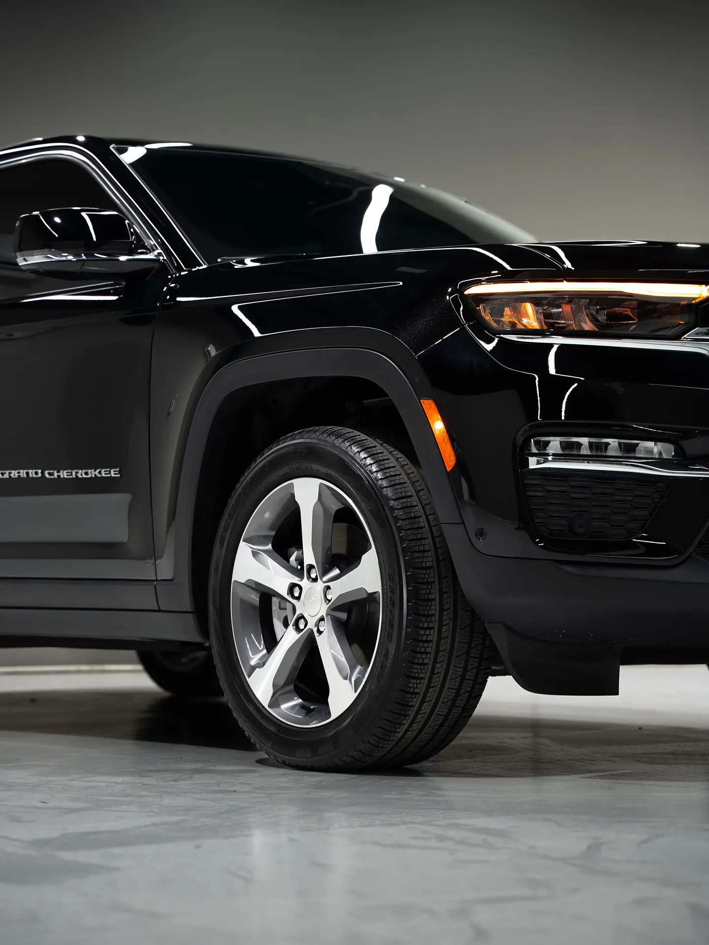 A black SUV in a lit showroom photographed from a three-quarter angle