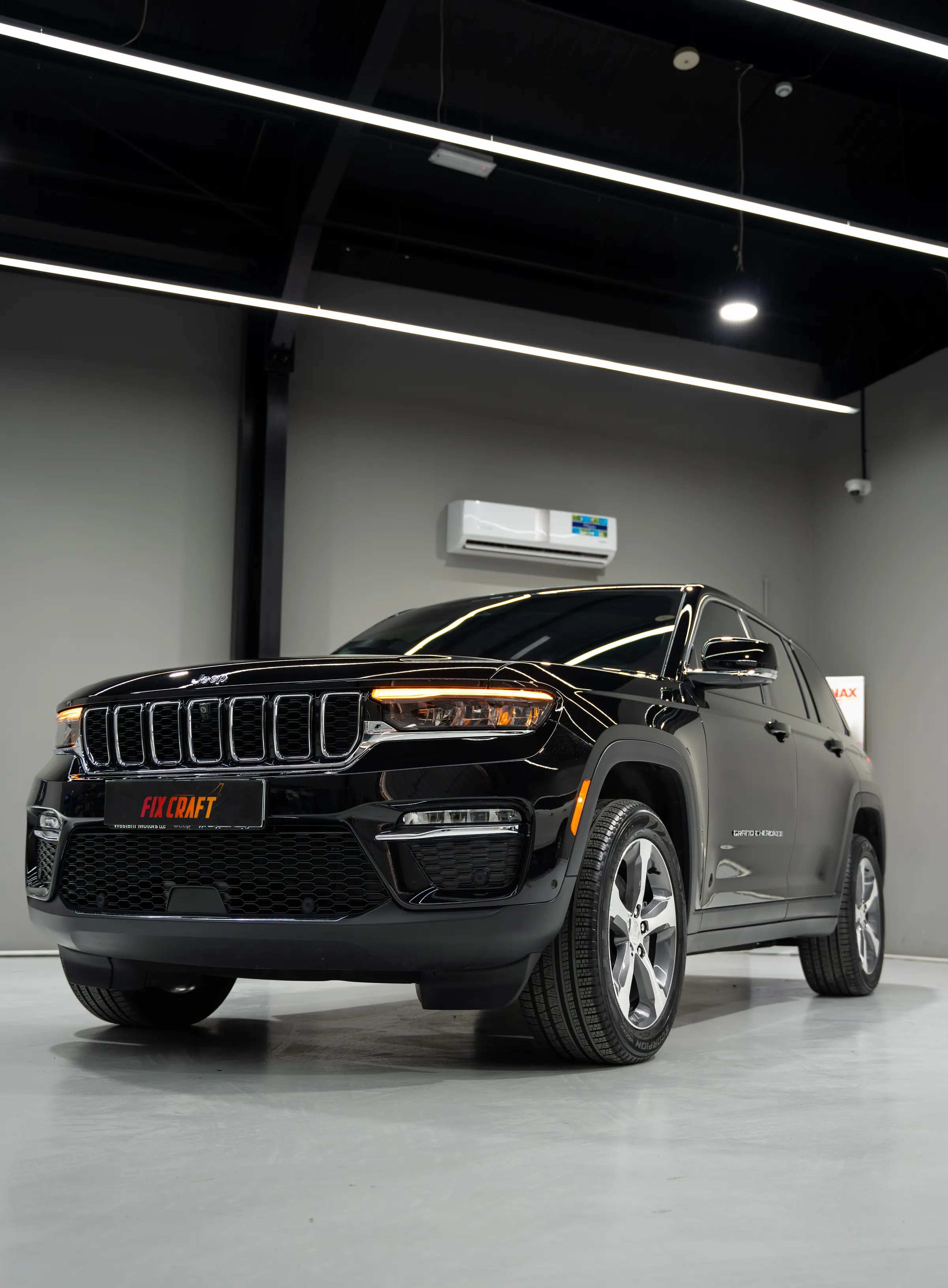 Black SUV photographed head-on in a lit workshop bay