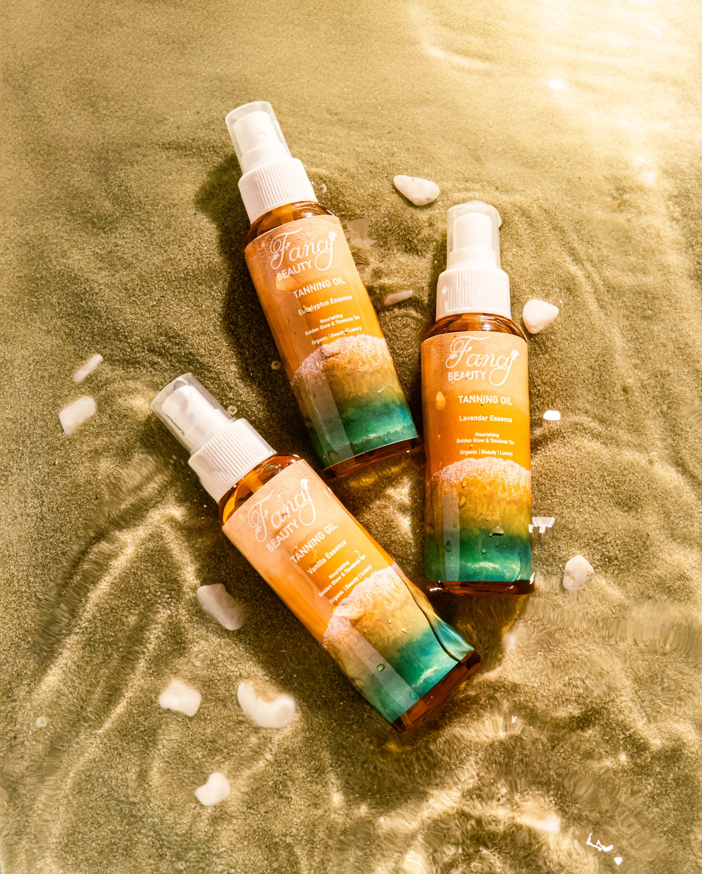 Two bottles of scented body mist arranged on sand with shells