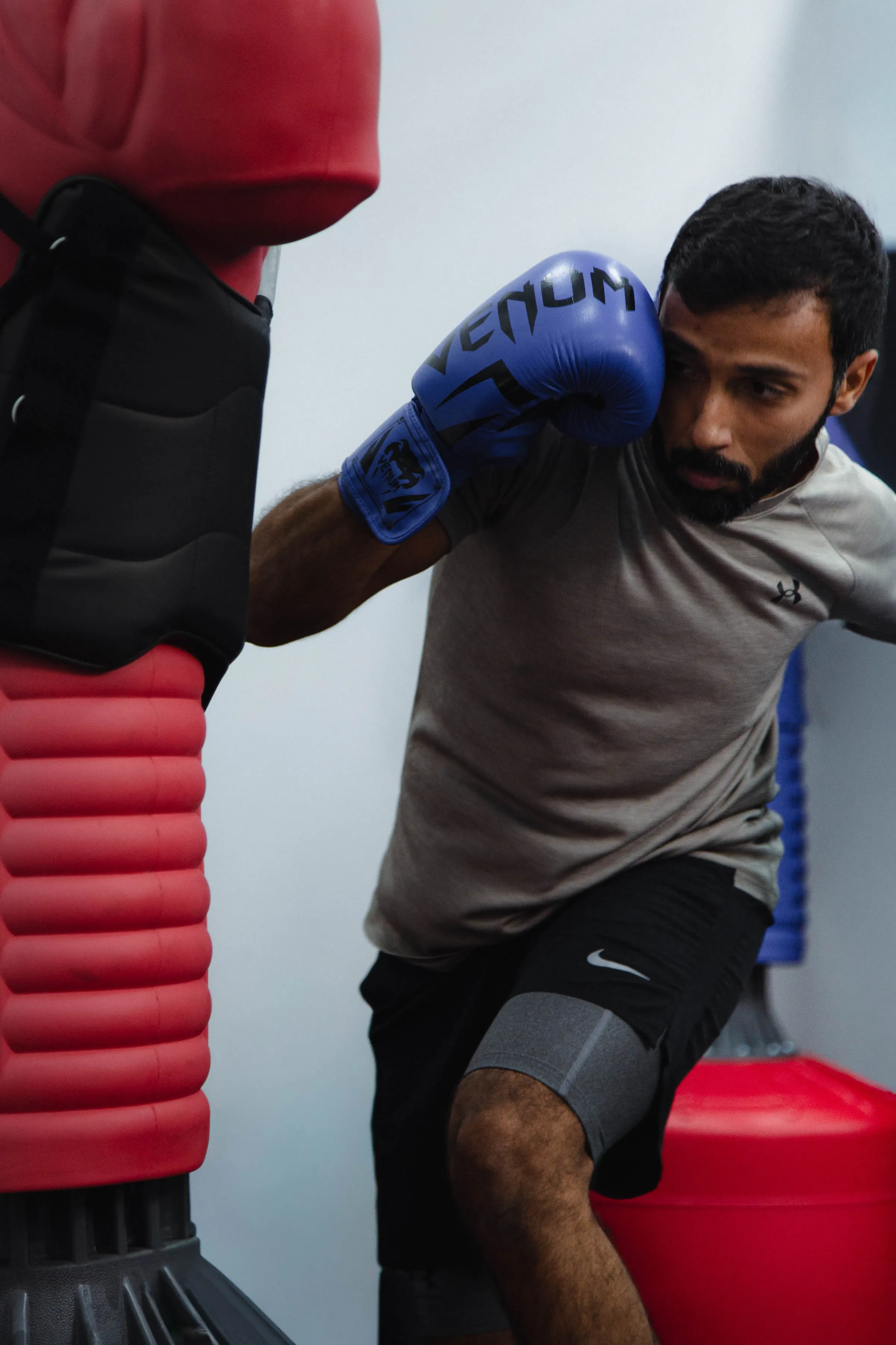 Boxer in gloves striking a free-standing punch bag