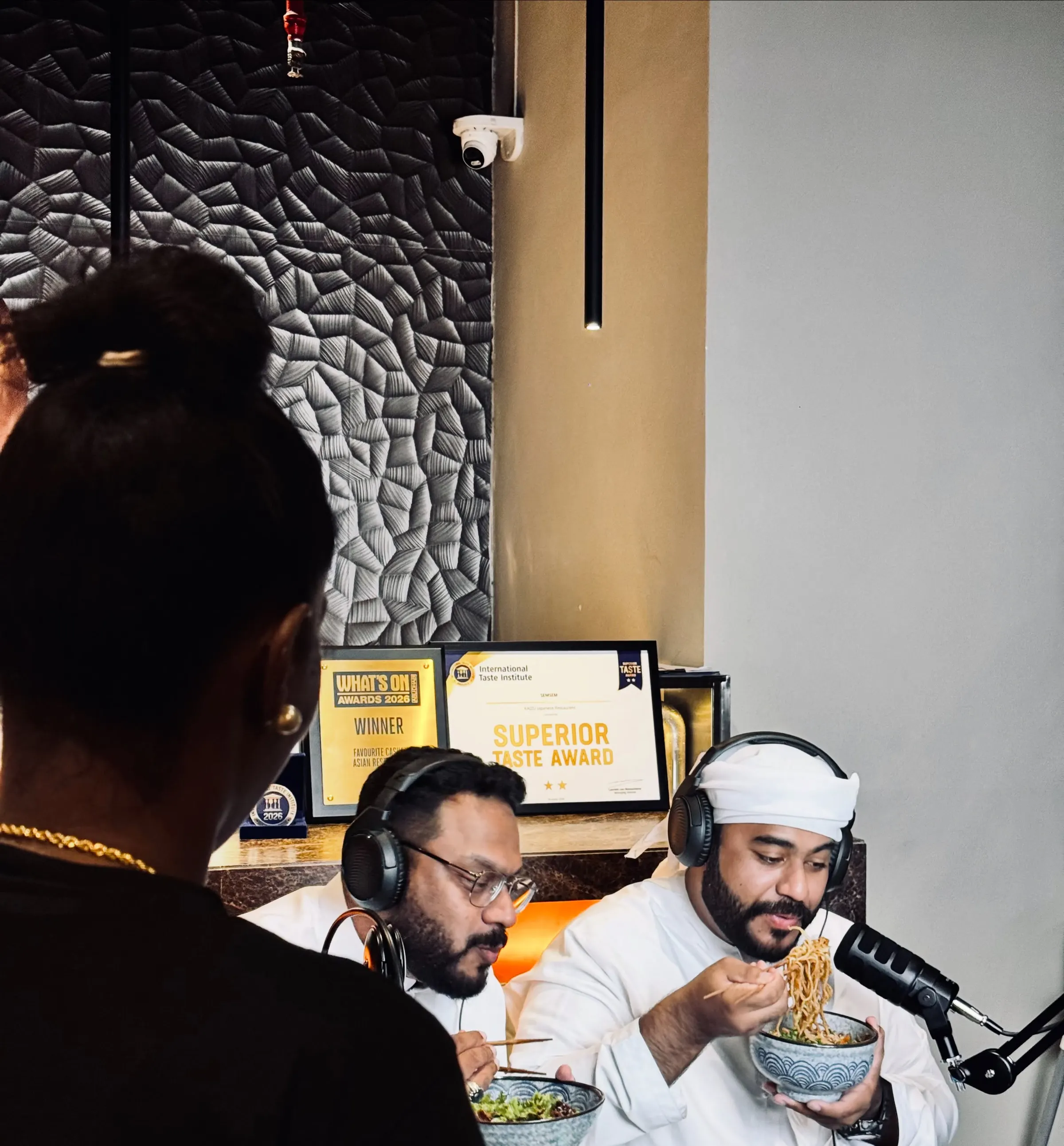 Over-shoulder view of a podcast being recorded in a restaurant