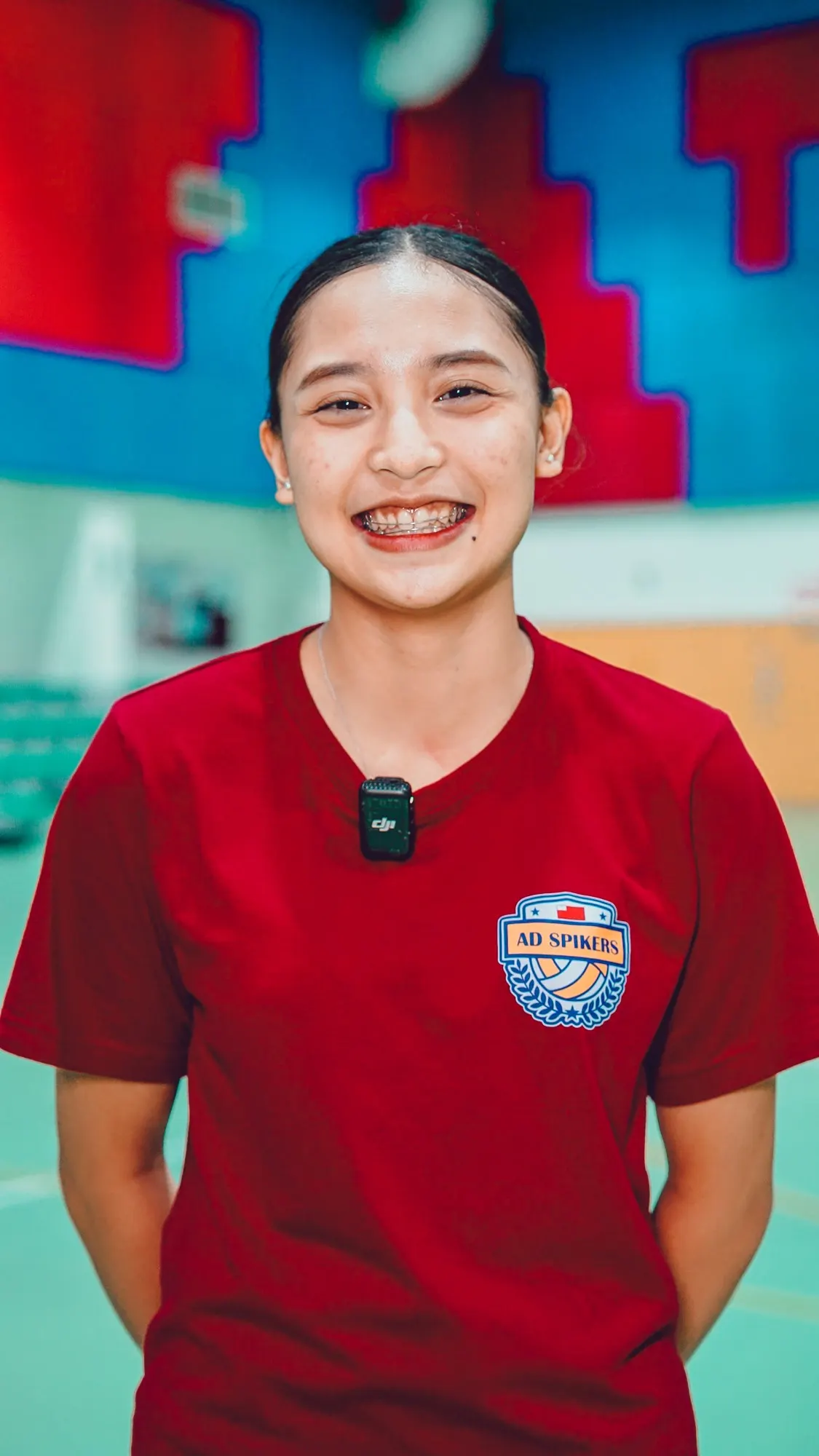 Heuy Ivanah Sarabillo smiling in a red AD Spikers shirt in a sports hall