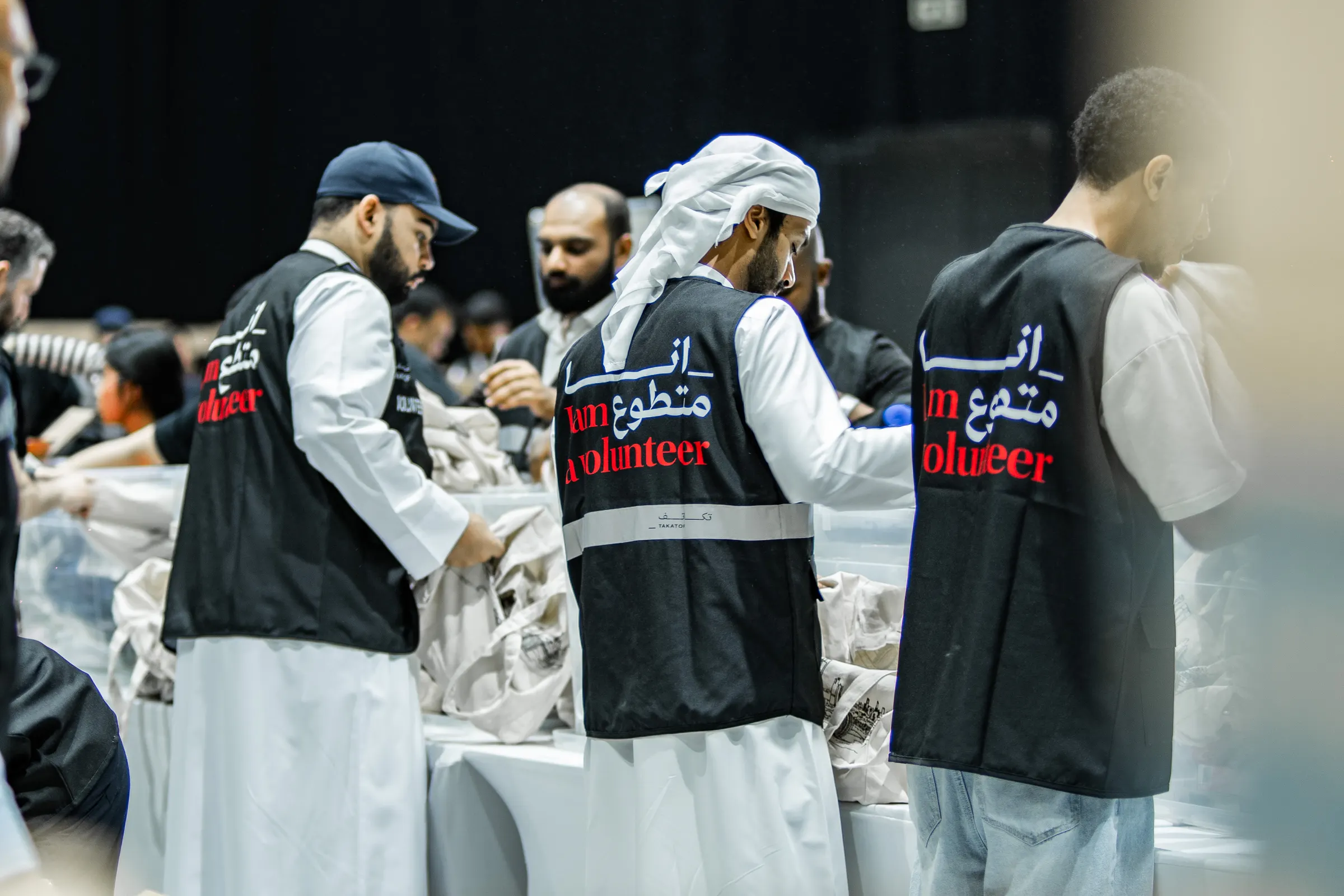 Volunteers in branded vests gathered at an event