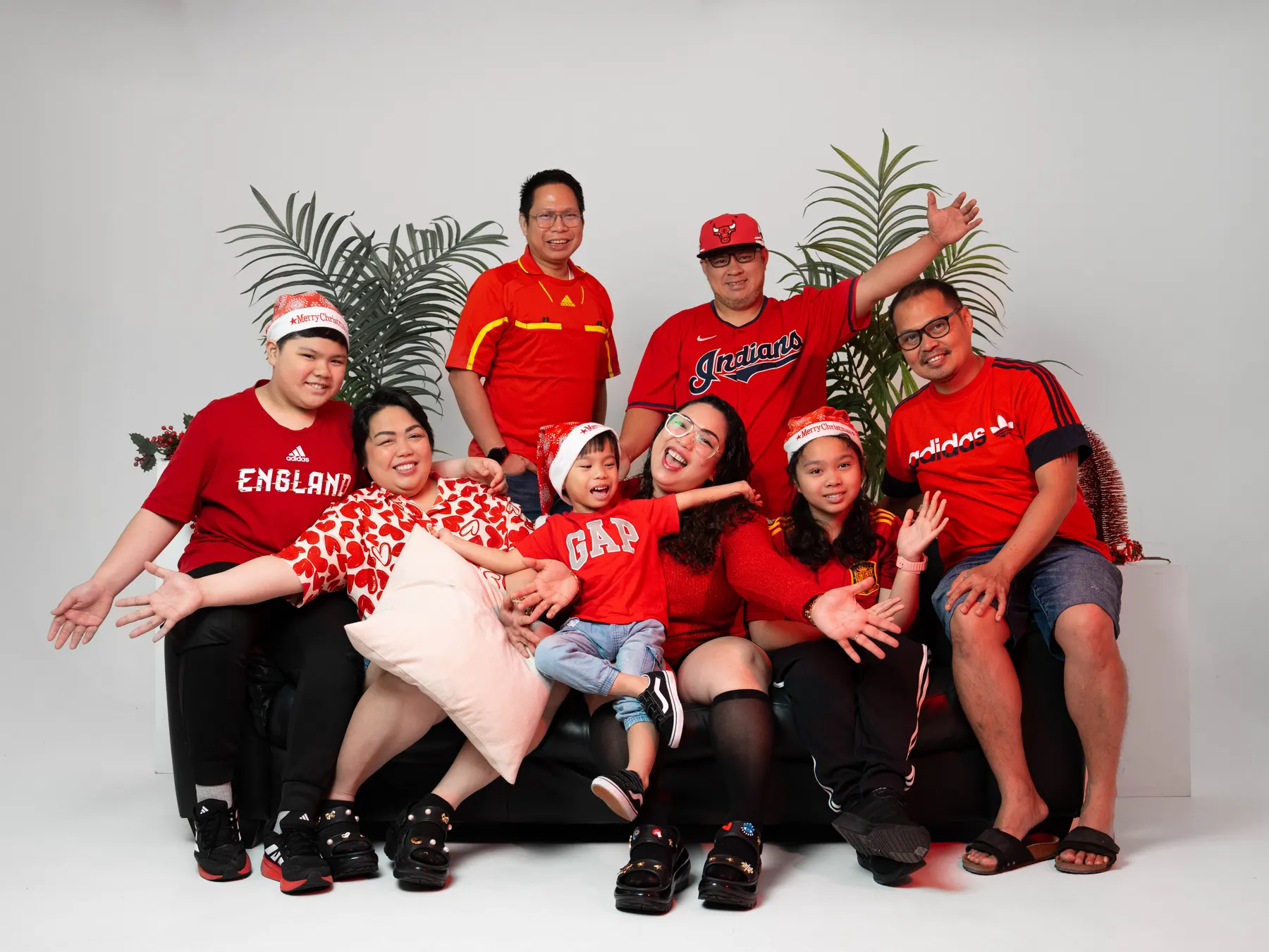 Family group in matching red shirts posing in a studio