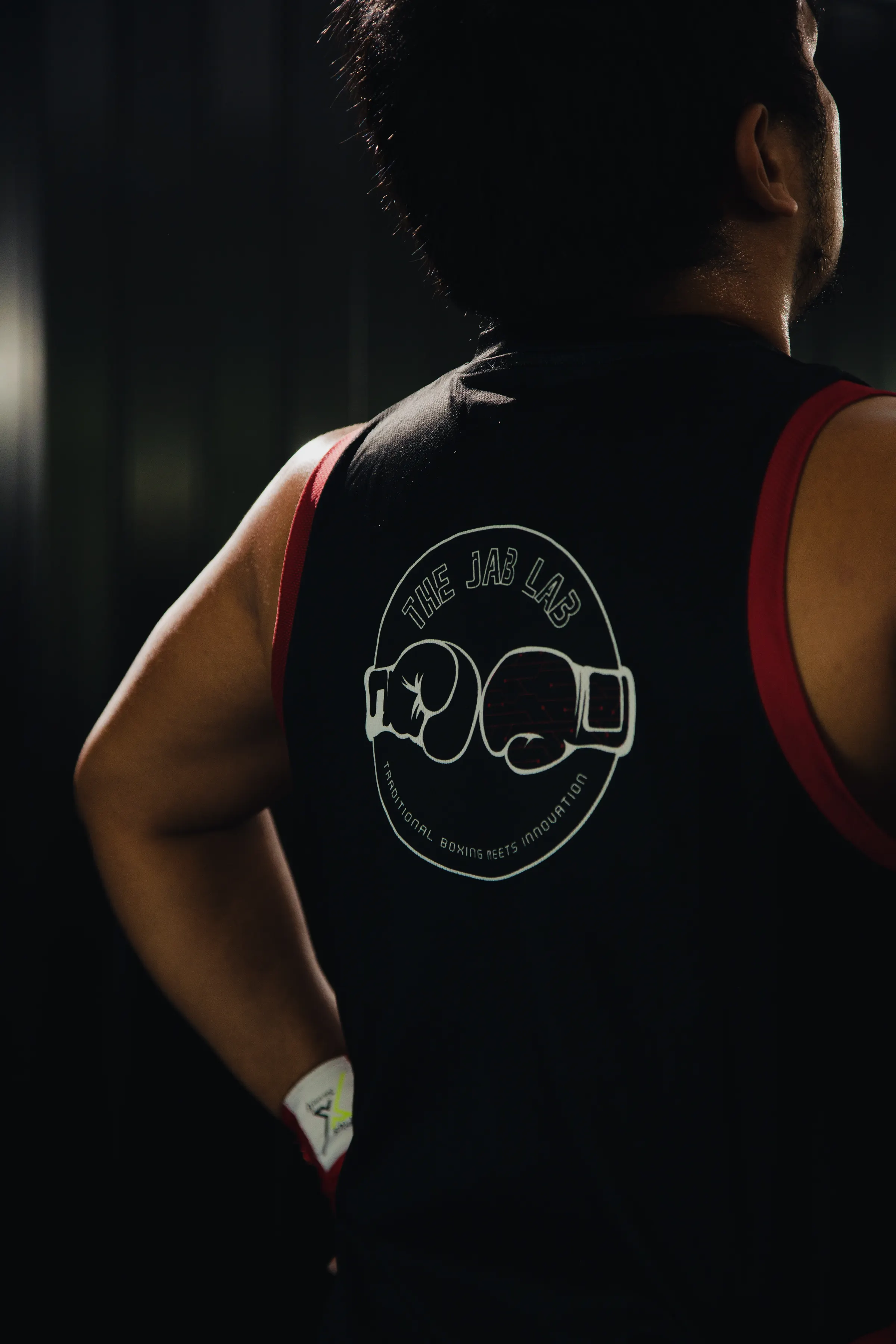 Athlete photographed from behind wearing a boxing club training vest