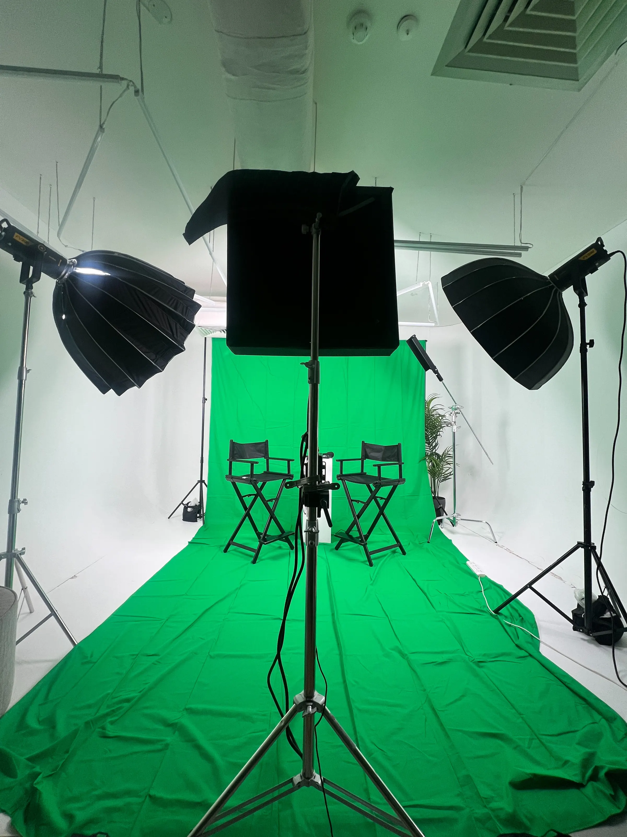 Green screen set with director's chairs, softboxes and a flag panel