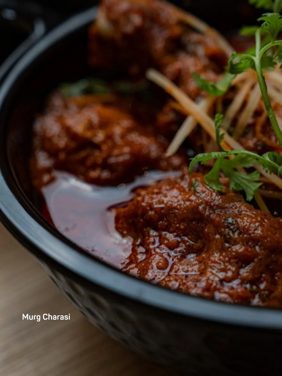 Close-up of a rich Murg Charasi curry served in a dark bowl