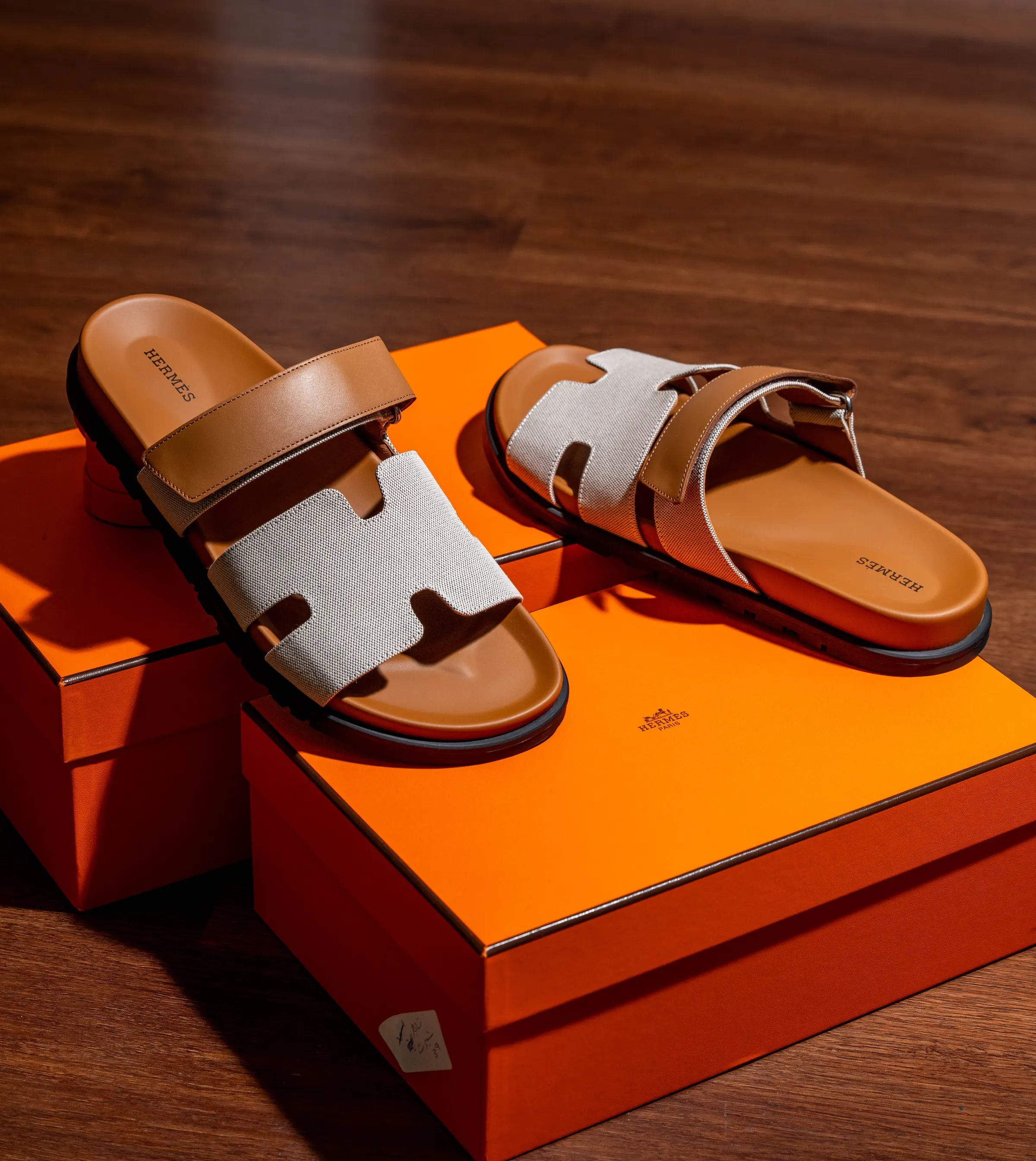 Pair of leather sandals displayed on an orange presentation box