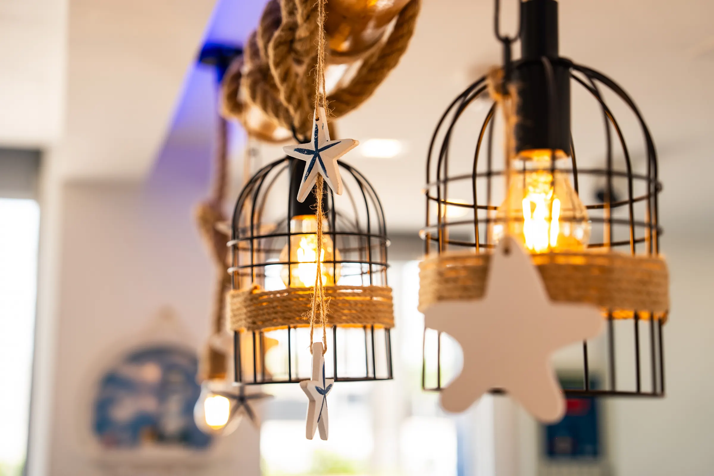 Cage pendant lights with rope and starfish detailing in a restaurant interior