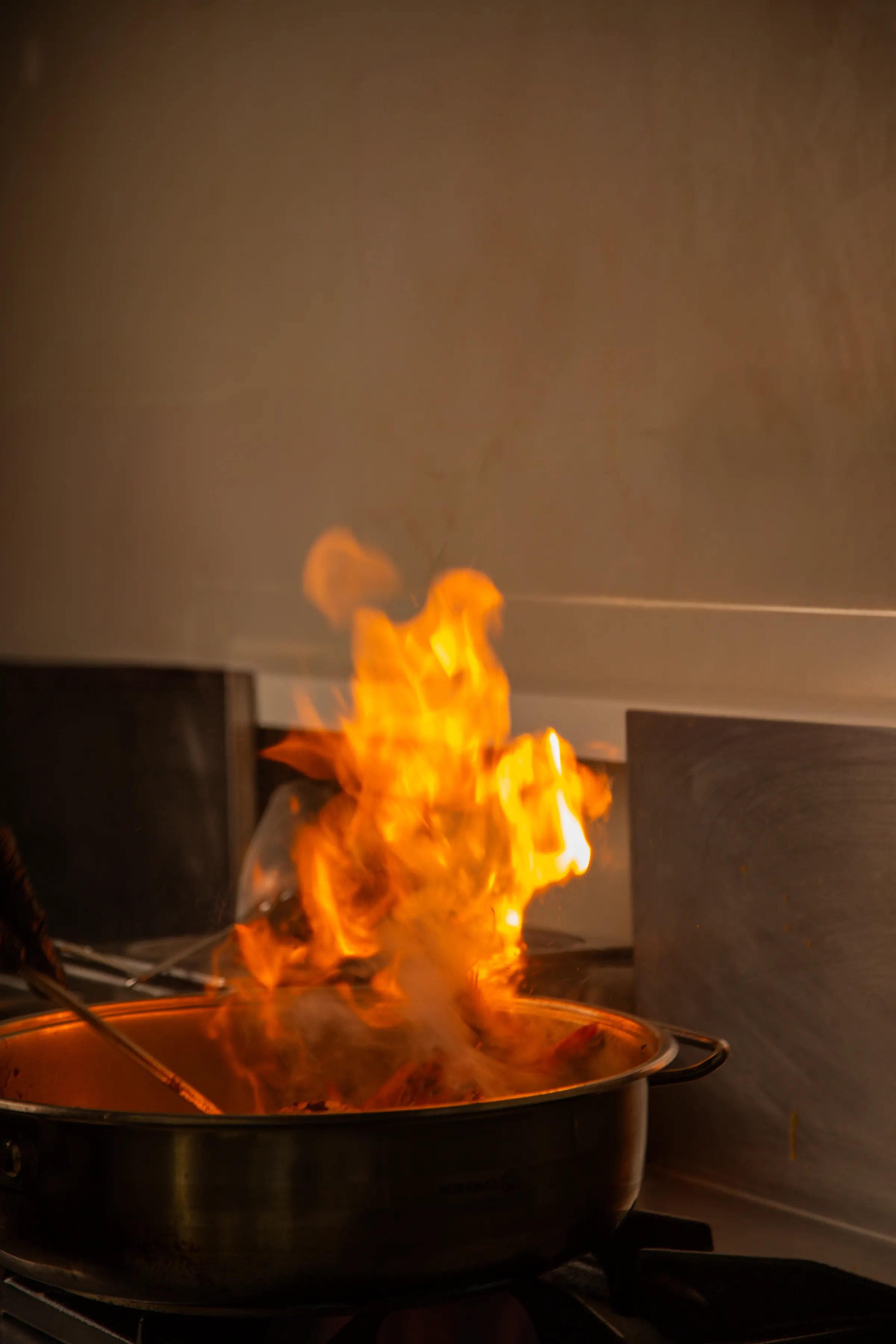 Flames rising from a cooking pan in a restaurant kitchen