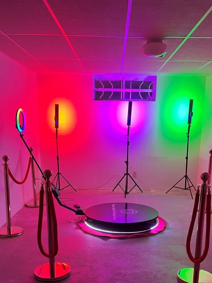 The studio lit with green, red and magenta practicals, a circular turntable platform and rope barriers on the floor